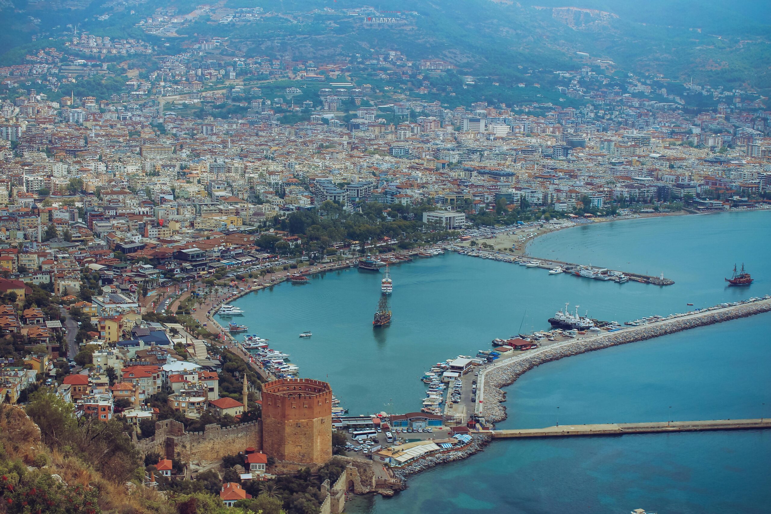 Breathtaking aerial view of Alanya harbor with cityscape and Red Tower in Türkiye.